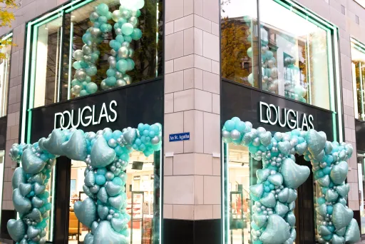 Douglas-Filiale mit türkisfarbener Ballondekoration an den Eingängen.