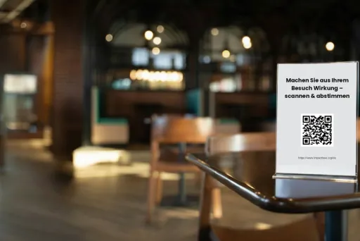 Tischaufsteller mit QR-Code in einem Restaurant laden Gäste dazu ein, den Code zu scannen und abzustimmen, um lokale Projekte zu unterstützen.