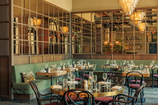 Elegant eingerichtetes Restaurant mit gedeckten Tischen und warmem Licht.