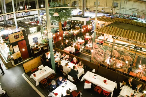 Großes, belebtes Restaurant mit festlich gedeckten Tischen und warmem Licht.