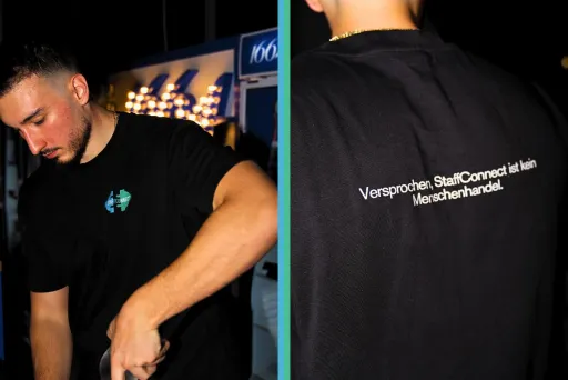 Junger Mann mit schwarzem T-Shirt, vorne mit Logo, hinten mit weißem Schriftzug.