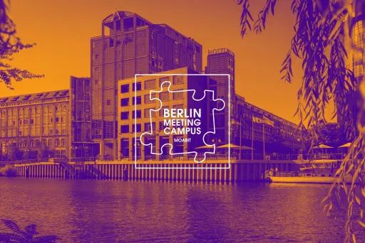 Spreeufer in Berlin-Moabit mit modernen Gebäuden und Berlin Meeting Campus Logo