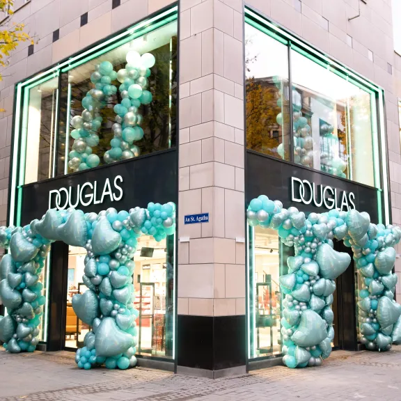 Douglas-Filiale mit türkisfarbener Ballondekoration an den Eingängen.