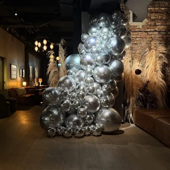 Große Ballon-Skulptur aus silbernen Kugeln in modernem, gemütlichem Innenraum.