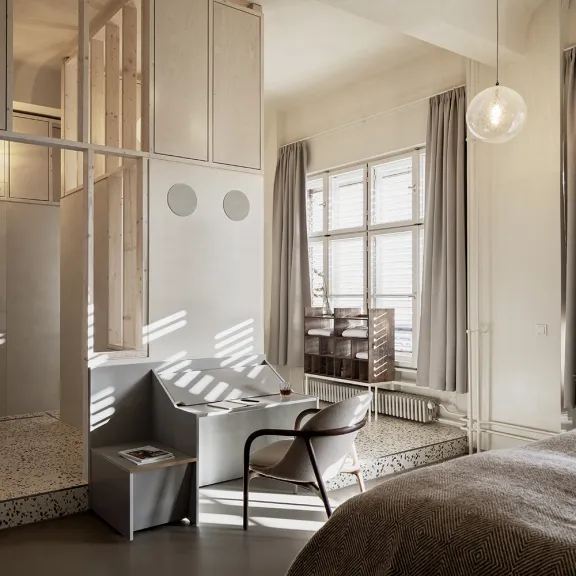 Das Luxus-Zimmer im Michelberger Hotel mit großem Doppelbett, Regendusche, Badewanne und lichtdurchflutetem Arbeitsbereich