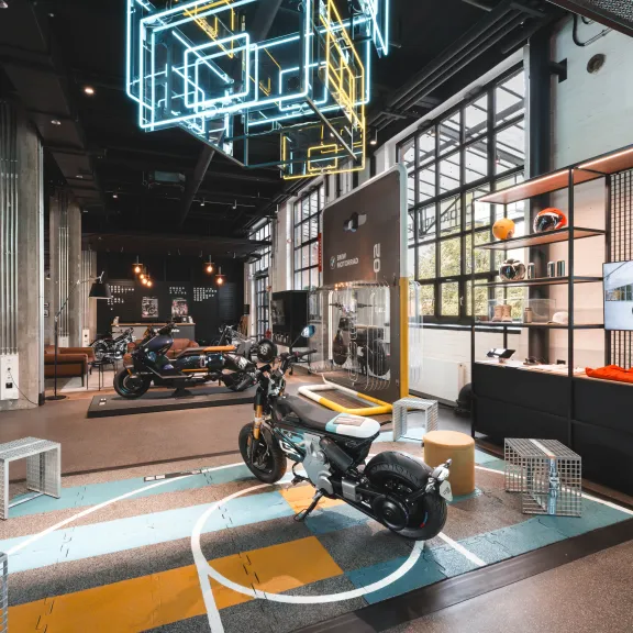 Motorrad Welt mit ausgestelltem Motorrad und leuchtender Neonbeleuchtung.