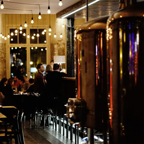 Brauerei mit Lichterketten und großen Kupfer-Biertanks.