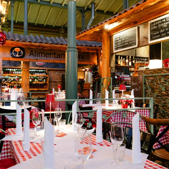 Gemütlich dekoriertes Restaurant mit rot-weiß karierten Tischdecken und Weihnachtsdeko.