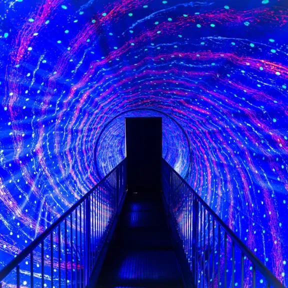 Leuchtender Gang mit spiralförmigen Lichtmustern in Blau und Lila