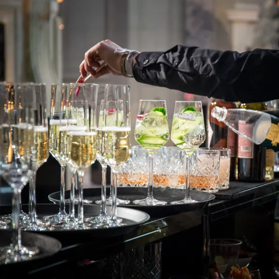 Barkeeper füllt Sekt in Gläser an einer festlich gedeckten Bar.