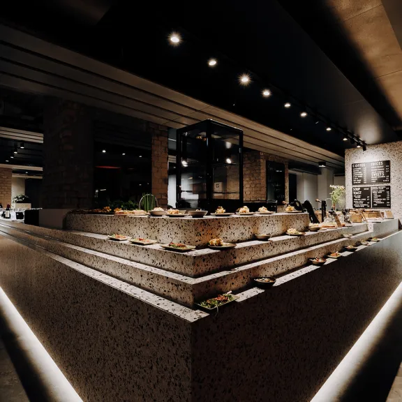 Modernes Restaurant mit Buffet und stimmungsvoller Beleuchtung.