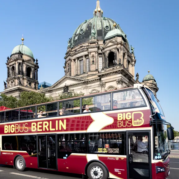 Doppeldecker-Touristenbus vor dem Berliner Dom bei klarem Himmel